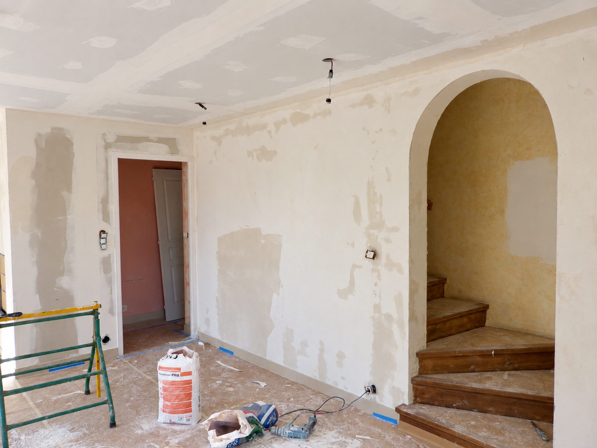 Application d'une couche d'enduit sur les murs.